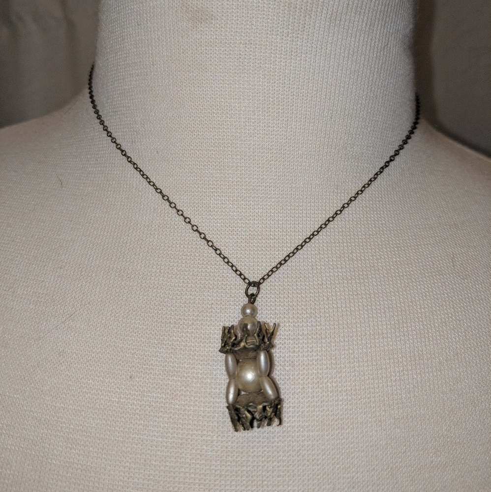 Vintage pearl and metal pendent on chain.